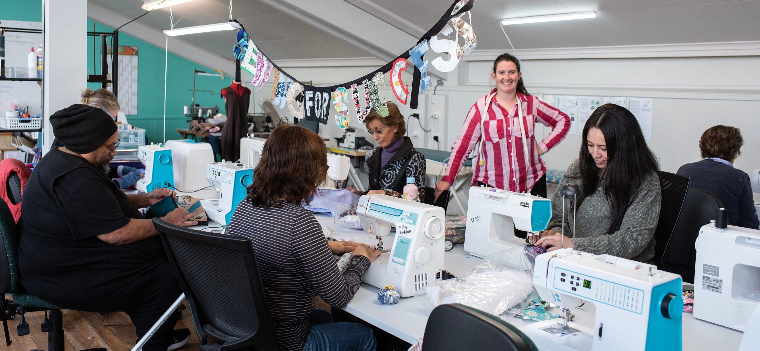 Sewing for Success sewing studio in Rotorua with people sewing on machines on a table